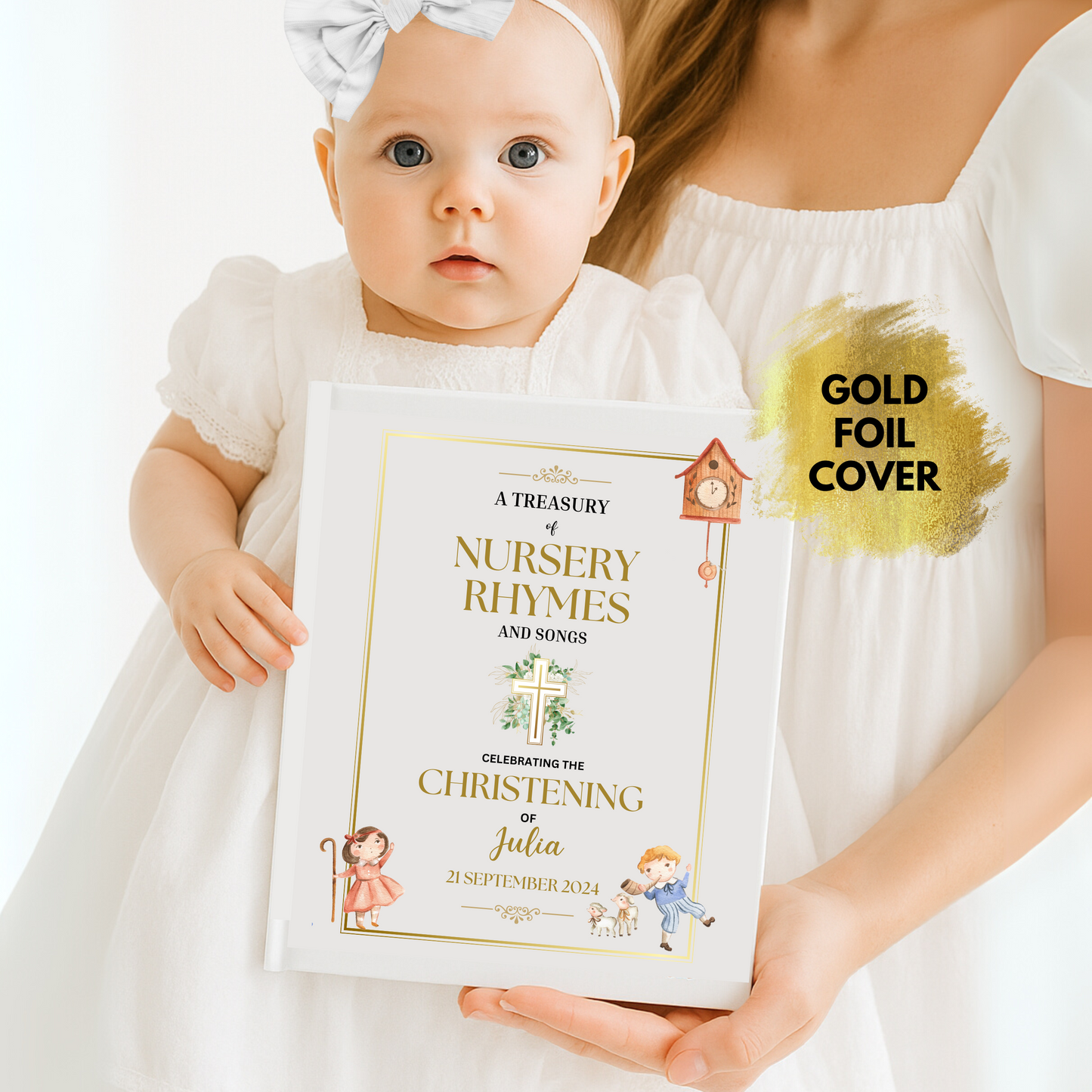 Baby holding a book titled 'A Treasury of Nursery Rhymes and Songs' with gold foil Christening cover, being held by an adult.